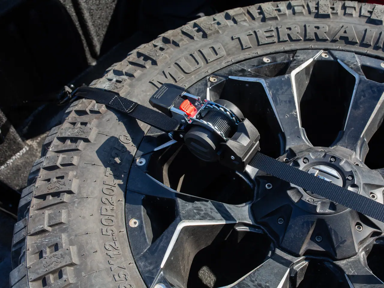 Ratchet strap securing a spare tyre in an off-road vehicle